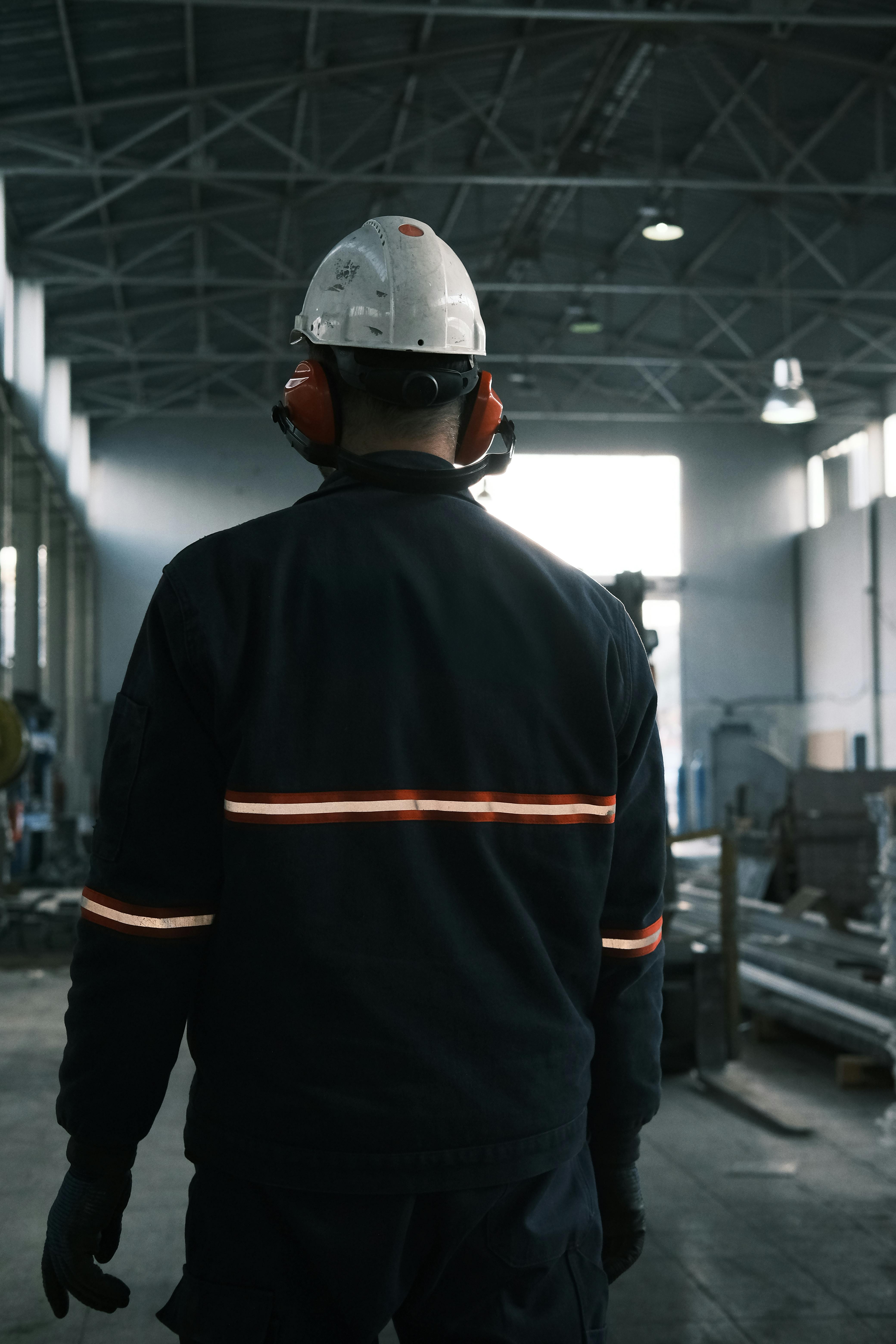 Opérateur en atelier avec casque et protections